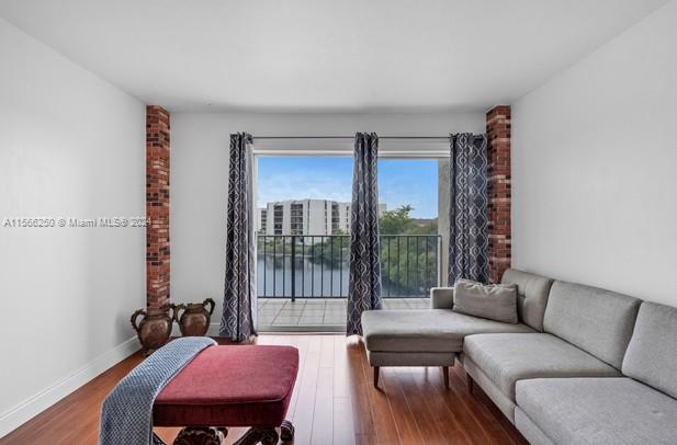 living room with brick wall and dark hardwood / wood-style floors