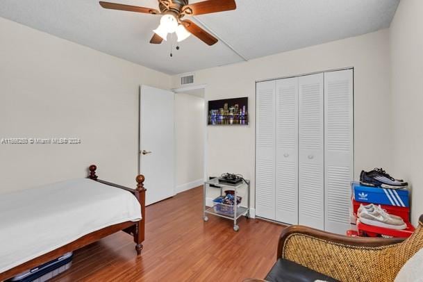 bedroom with ceiling fan, light hardwood / wood-style flooring, and a closet