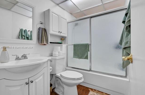 full bathroom featuring vanity, combined bath / shower with glass door, wood-type flooring, and toilet