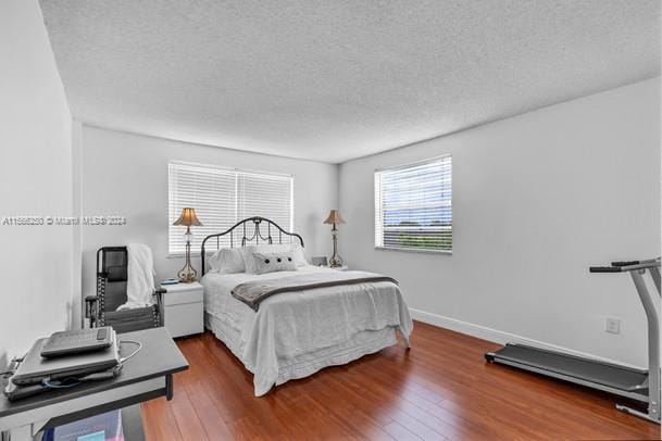 bedroom featuring dark hardwood / wood-style flooring and a textured ceiling