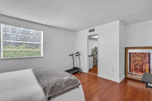 bedroom with dark wood-type flooring and a textured ceiling