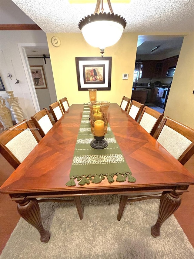 dining room featuring a textured ceiling and carpet flooring