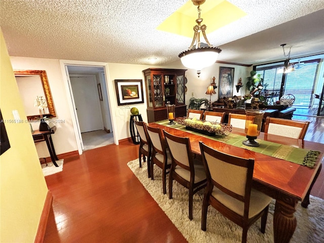 dining space with a textured ceiling and hardwood / wood-style flooring