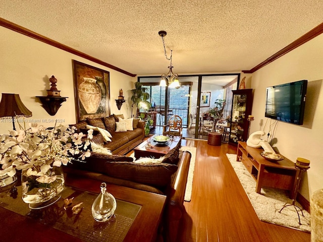 living room featuring hardwood / wood-style flooring, a wall of windows, ornamental molding, and an inviting chandelier