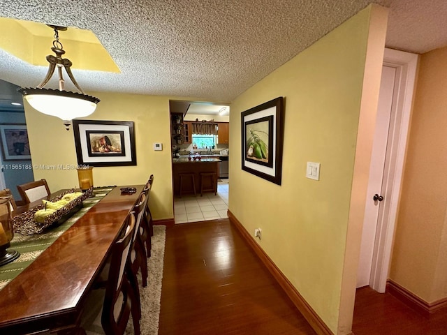 unfurnished dining area with a textured ceiling and light hardwood / wood-style floors