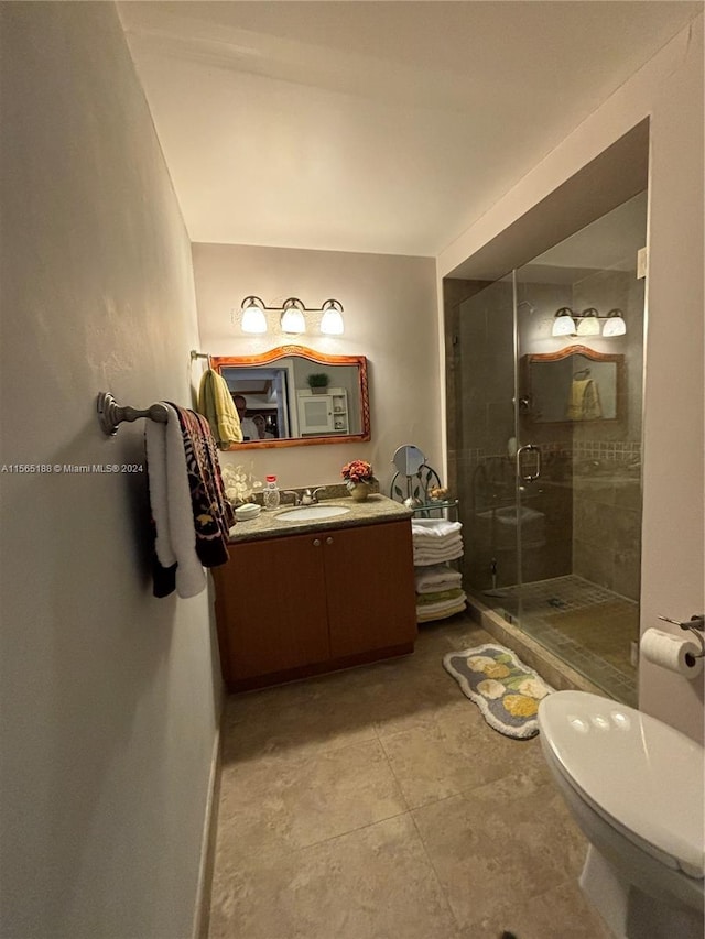 bathroom with vanity, toilet, and a shower with shower door