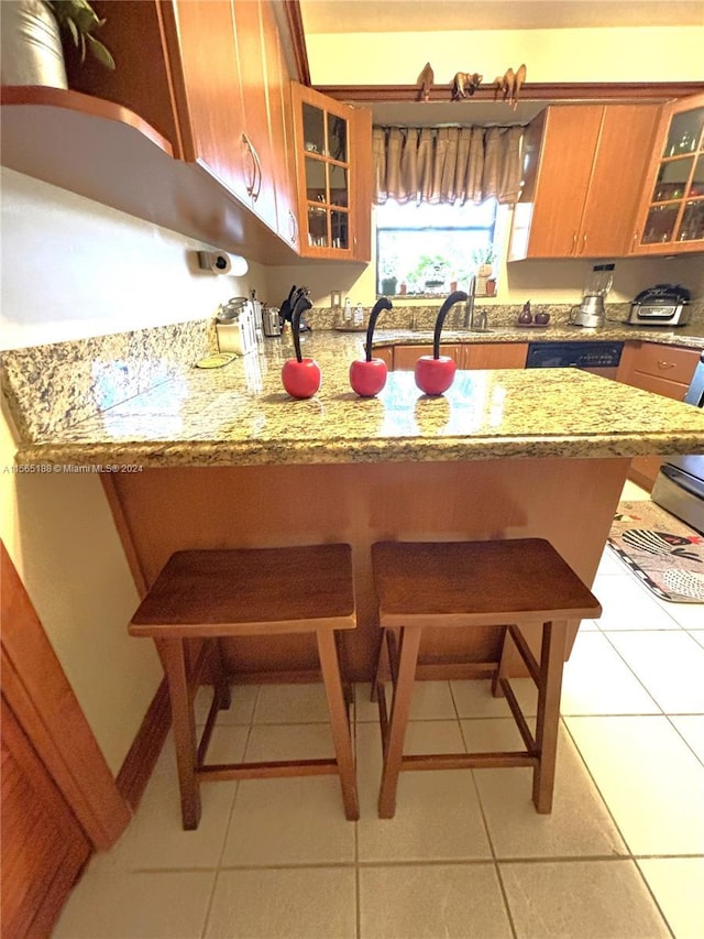 kitchen with light stone countertops, sink, and light tile patterned floors