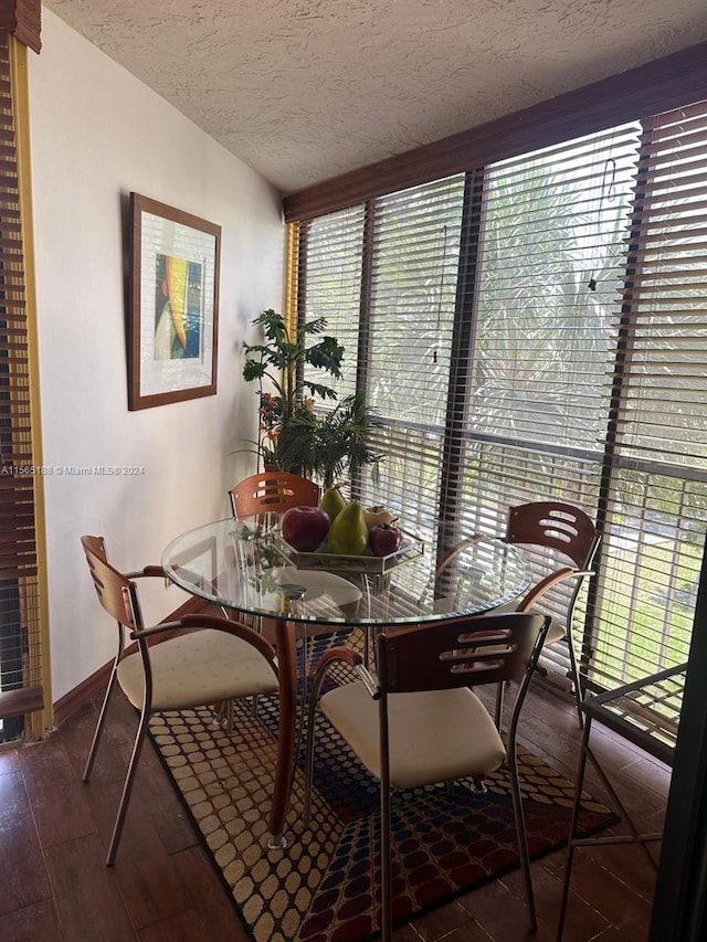 dining space featuring hardwood / wood-style flooring, floor to ceiling windows, a textured ceiling, and a wealth of natural light