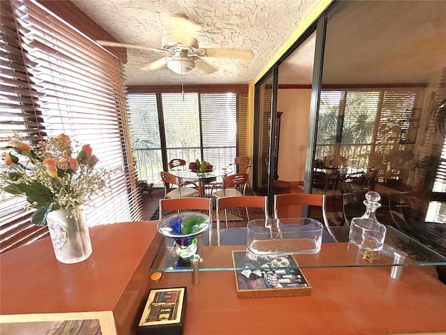 dining space featuring ceiling fan and a textured ceiling