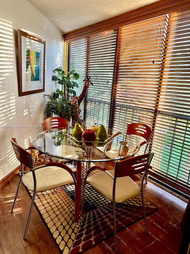 dining area with hardwood / wood-style flooring and a textured ceiling