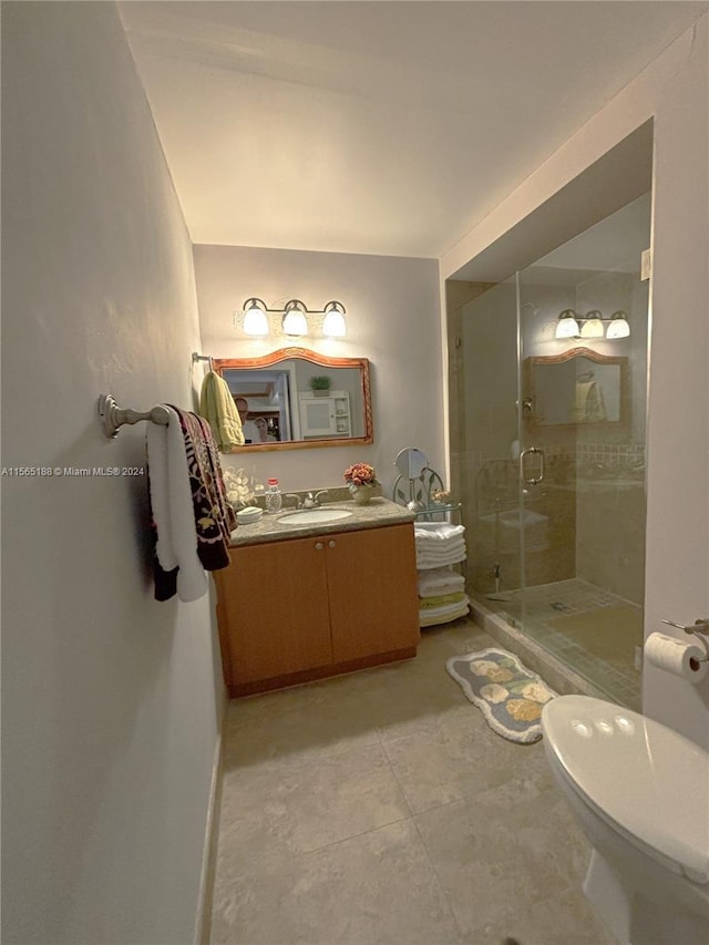 bathroom featuring vanity, a shower with shower door, tile patterned floors, and toilet