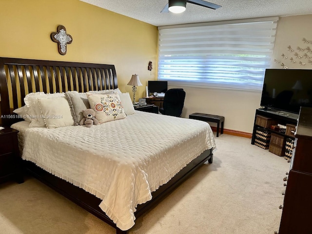 carpeted bedroom featuring ceiling fan and a textured ceiling