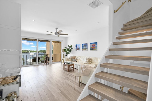 staircase featuring hardwood / wood-style flooring and ceiling fan