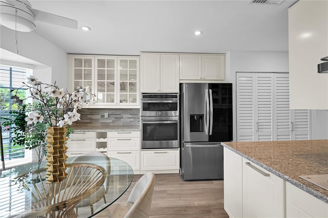 4234 N Ocean Dr, Hollywood, FL 33019 - kitchen with appliances with stainless steel finishes, decorative backsplash, glass insert cabinets, recessed lighting, and light wood-type flooring
