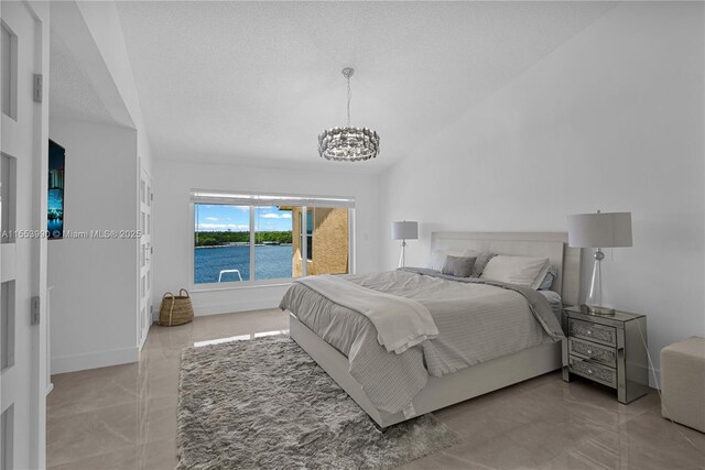 4234 N Ocean Dr, Hollywood, FL 33019 - bedroom featuring a chandelier, lofted ceiling, a textured ceiling, and a water view