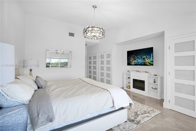 bedroom featuring an inviting chandelier and high vaulted ceiling