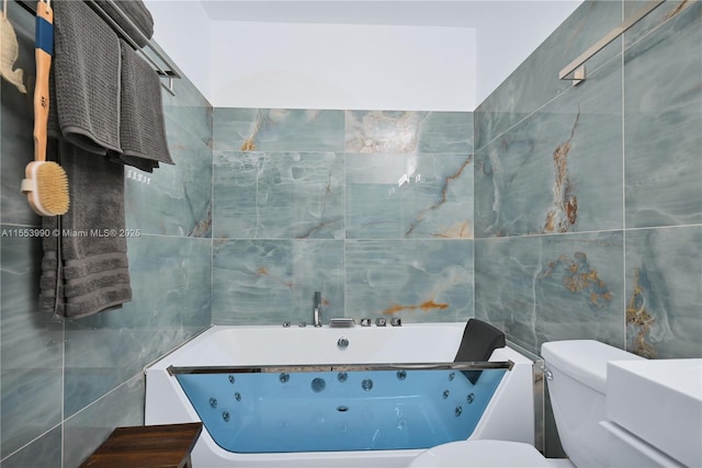 bathroom featuring tile walls, a washtub, and toilet