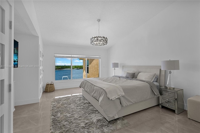 bedroom with lofted ceiling, a textured ceiling, and a water view