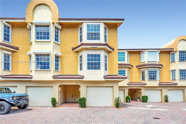 4234 N Ocean Dr, Hollywood, FL 33019 - view of property featuring a tile roof, stucco siding, and an attached garage