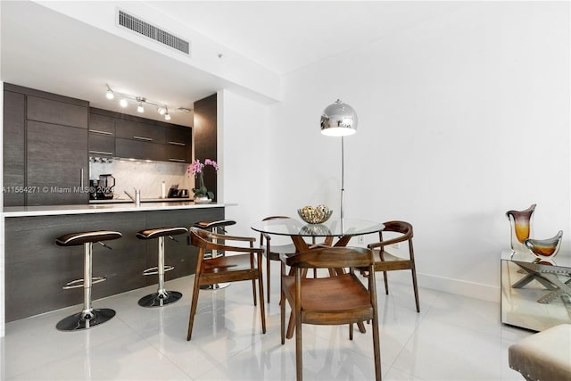 tiled dining room featuring track lighting