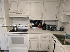 kitchen featuring white cabinets, white electric range oven, and sink