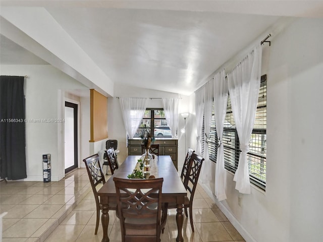 dining room featuring light tile floors and lofted ceiling