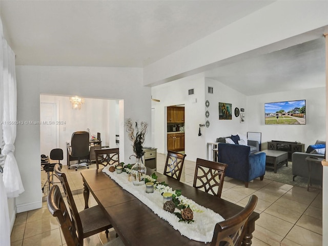 tiled dining space with a notable chandelier and vaulted ceiling