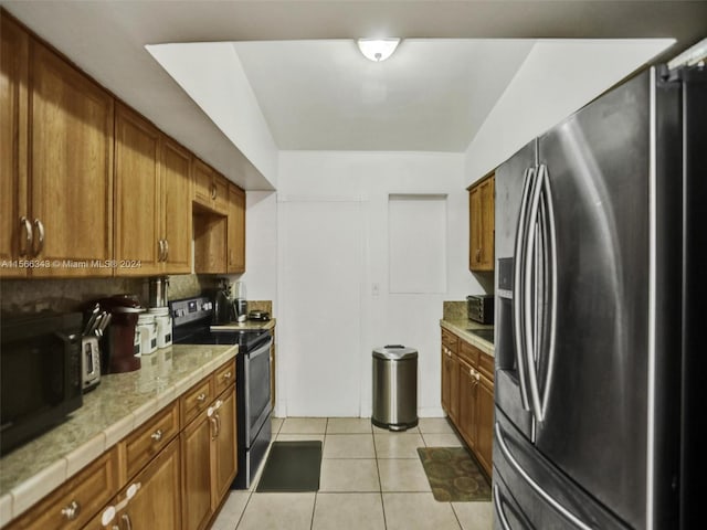 kitchen featuring appliances with stainless steel finishes, tasteful backsplash, and light tile floors