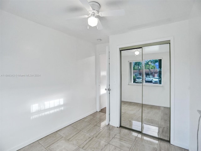 unfurnished bedroom with a closet, ceiling fan, and light tile flooring