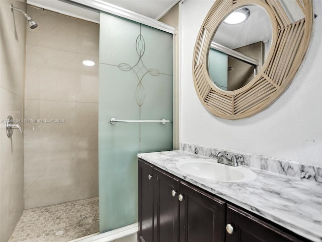 bathroom with vanity with extensive cabinet space and tiled shower