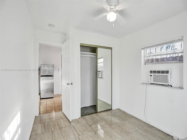 unfurnished bedroom featuring ceiling fan, a closet, stainless steel fridge, and light tile floors