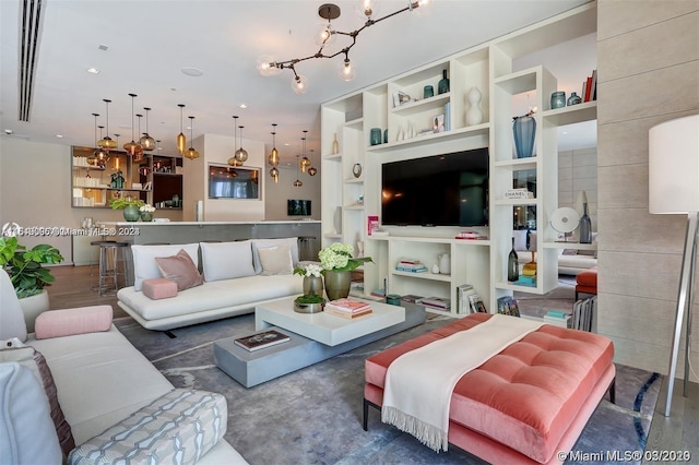 living room with built in shelves and a chandelier