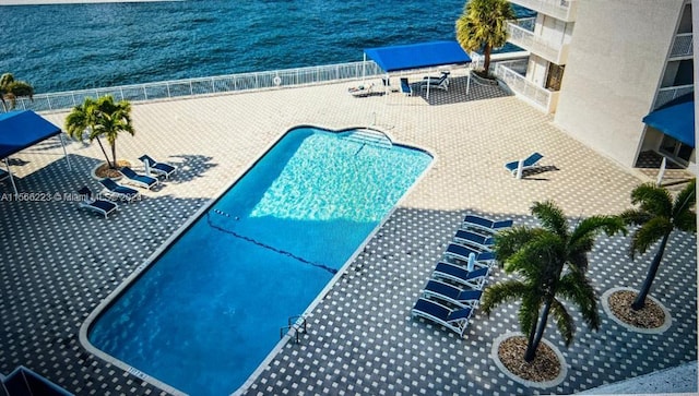 view of pool with a water view and a patio