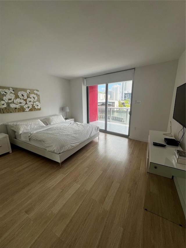 bedroom with access to exterior and light wood-type flooring