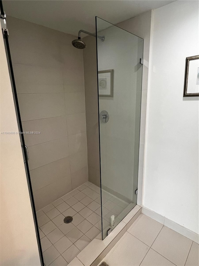 bathroom featuring tile flooring and tiled shower