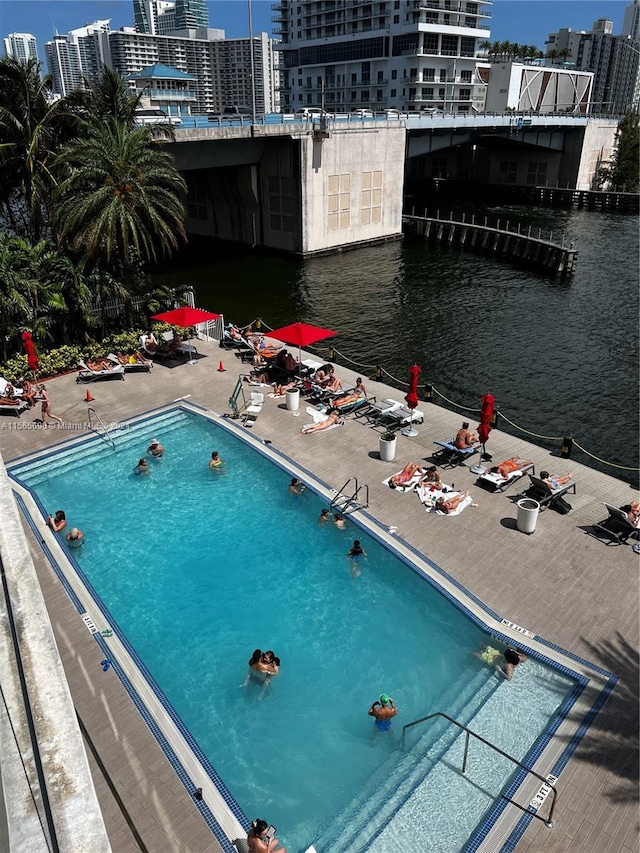 view of pool with a patio and a water view