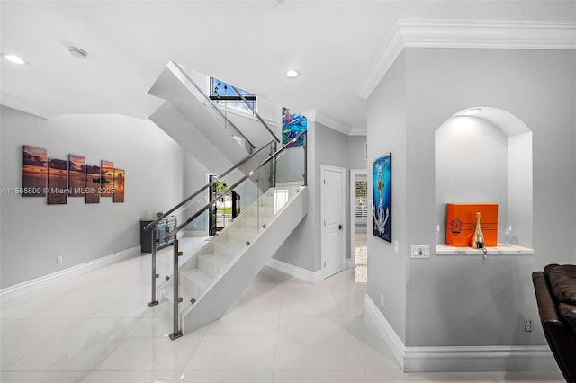 staircase featuring tile patterned floors and ornamental molding