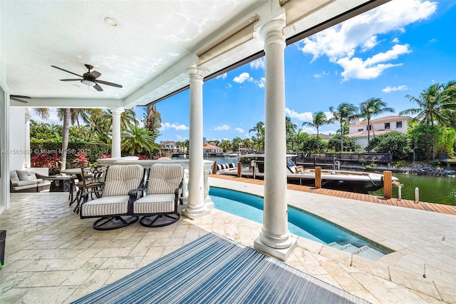 view of patio / terrace featuring a water view, a dock, and ceiling fan