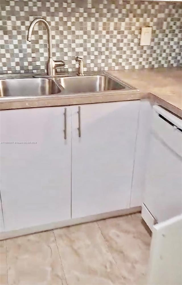 kitchen with white cabinets, tasteful backsplash, and sink