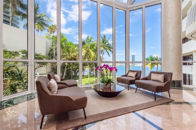 sunroom featuring a water view