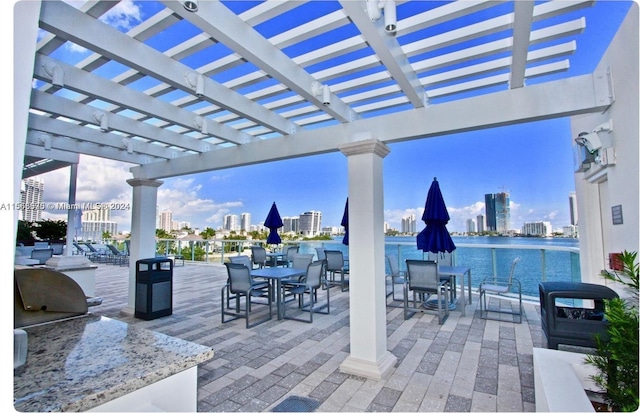 view of patio / terrace with a water view and a pergola