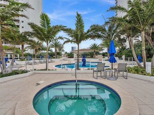 view of swimming pool with a hot tub and a patio