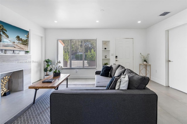 living room featuring built in features and a high end fireplace