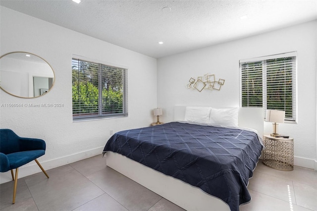 bedroom with a textured ceiling and light tile patterned floors