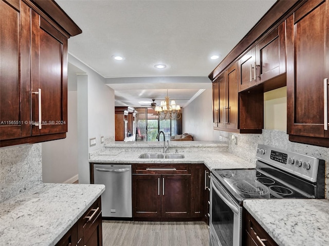 kitchen with appliances with stainless steel finishes, sink, backsplash, and an inviting chandelier