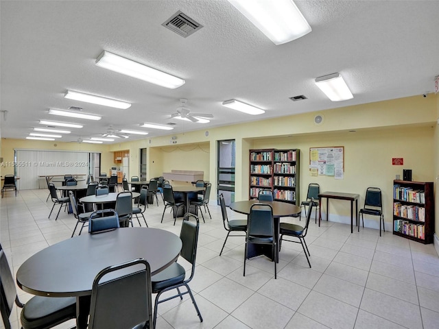 dining room featuring ceiling fan, light tile floors, and a textured ceiling