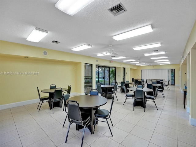 tiled dining room featuring a textured ceiling and ceiling fan