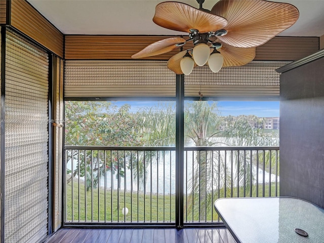 unfurnished sunroom with ceiling fan