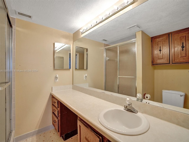 bathroom featuring walk in shower, toilet, tile floors, and large vanity