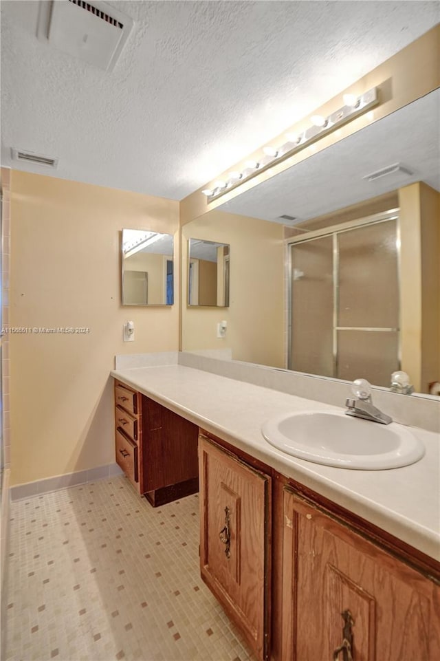 bathroom featuring tile floors, a textured ceiling, and vanity